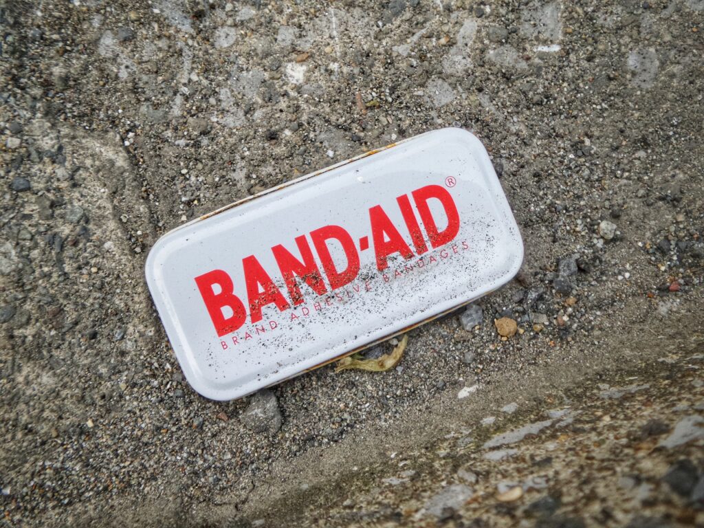 Band Aid Box lying in soil to illustrate booting your soils health